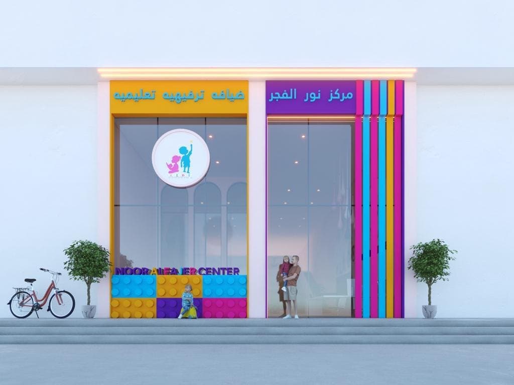 Children's centre shopfront with a vertical rainbow-striped pilaster, illustrated signage band and planting either side of the entrance