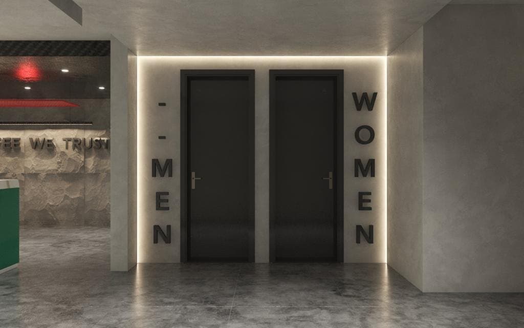 Interior wayfinding: backlit MEN and WOMEN lettering flanking two dark timber washroom doors