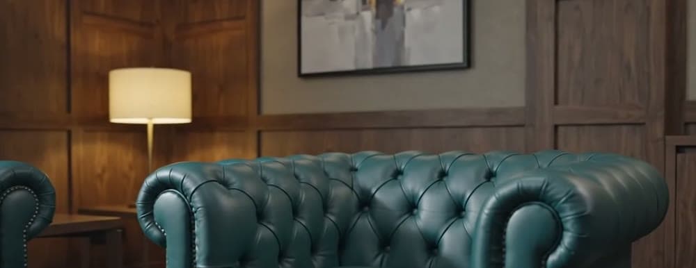 Buttoned leather seating in a timber-panelled room