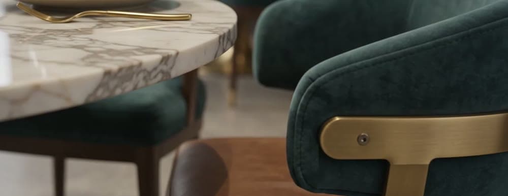 Marble table edge with a brass-detailed upholstered chair