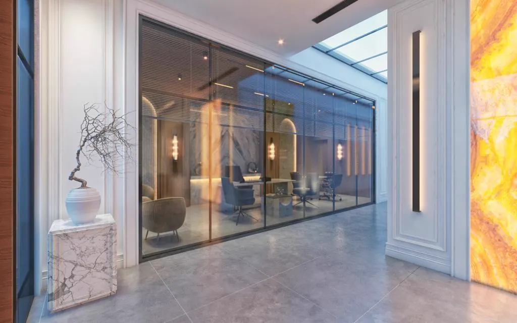 Hotel lobby corridor with a backlit onyx wall and glazed partitions