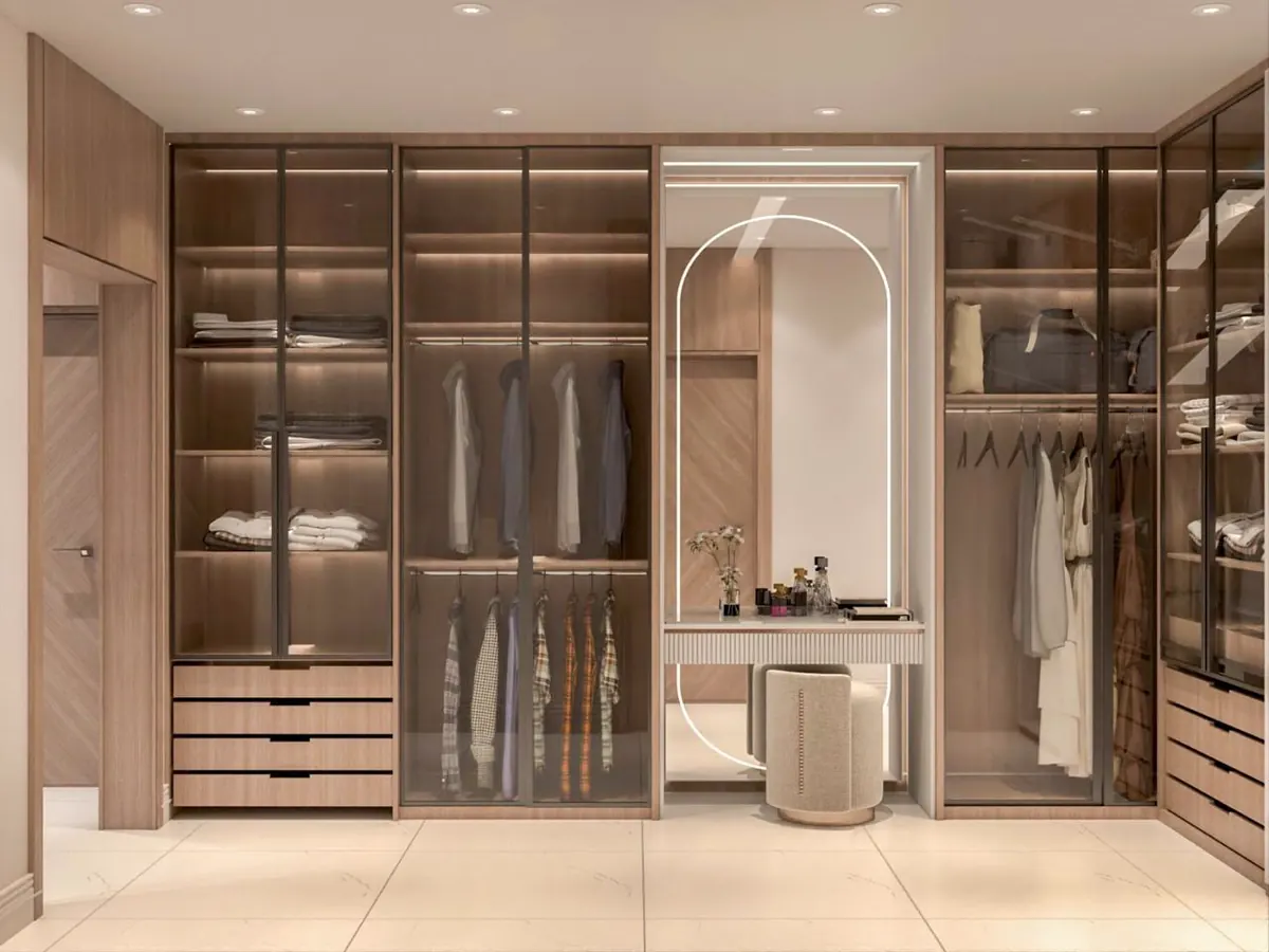Walk-in wardrobe with glass-fronted units and integrated lighting